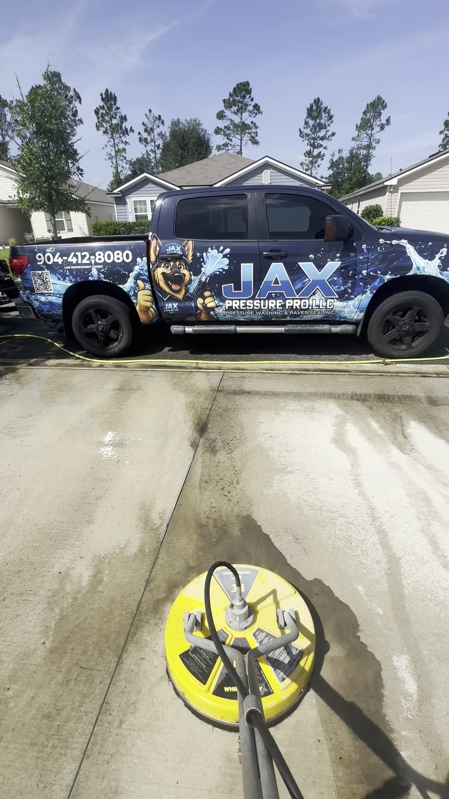 Jax Pressure Pro branded truck and professional surface cleaner at a driveway project